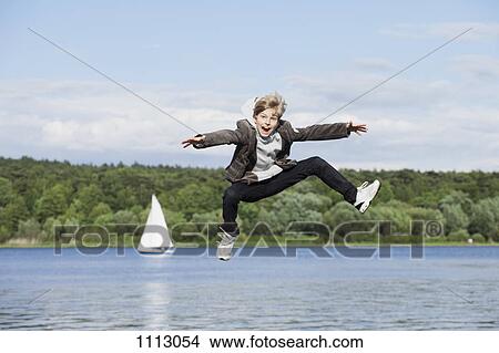 An adolescent boy jumping in the air View Large Photo Image Picture - An adolescent boy jumping in the air. Fotosearch