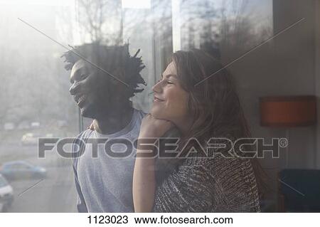 Stock Image - An affectionate couple looking out a window. Fotosearch