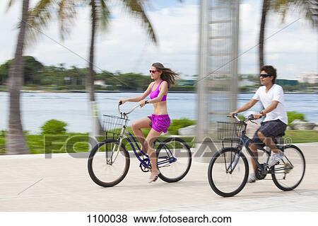 Stock Photo - Boy and girl cycling on promenade. Fotosearch