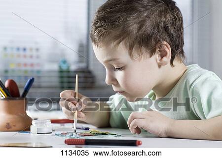 Stock Photography - Boy Painting in workshop. Fotosearch