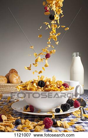 Cereal and fruit being poured into a bowl View Large Photo Image Stock Photo - Cereal and fruit being poured into a bowl. Fotosearch