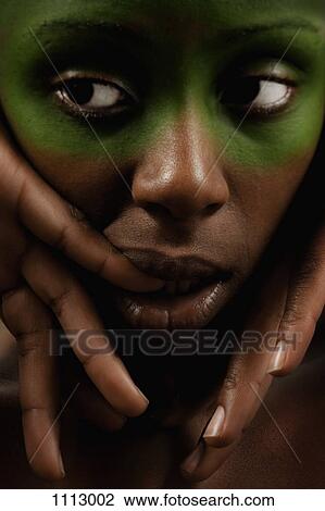 Stock Image - Close-up portrait of a woman looking to the side with uncertainty. Fotosearch