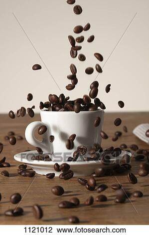 Coffee beans being poured into a cup View Large Photo Image Stock Image - Coffee beans being poured into a cup. Fotosearch