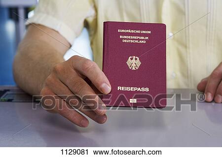 Detail of a man holding a German passport View Large Photo Image Stock Image - Detail of a man holding a German passport. Fotosearch