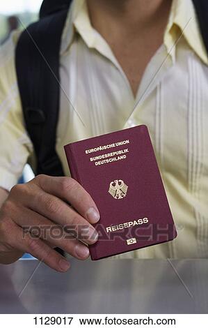 Stock Photo - Detail of a man holding a German passport. Fotosearch