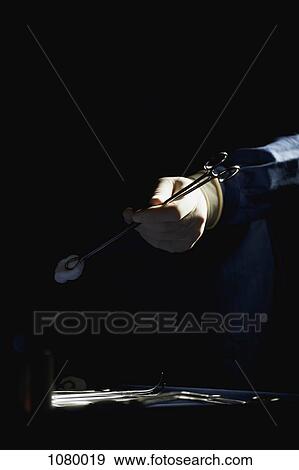 Detail of a man holding a surgical instrument View Large Photo Image Stock Photo - Detail of a man holding a surgical instrument. Fotosearch