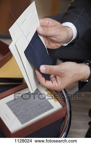 Detail of a man holding fabric samples View Large Photo Image Picture - Detail of a man holding fabric samples. Fotosearch