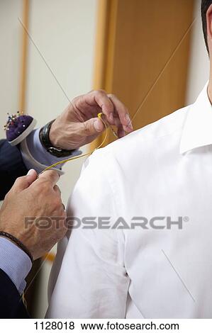 Detail of a tailor measuring the shoulder of a man View Large Photo Image Stock Photo - Detail of a tailor measuring the shoulder of a man. Fotosearch