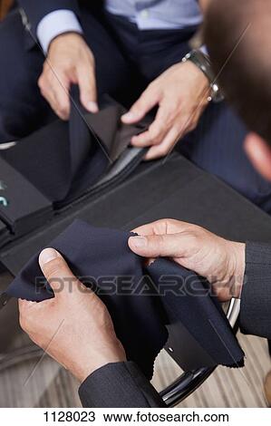 Detail of two men holding fabric samples View Large Photo Image Stock Image - Detail of two men holding fabric samples. Fotosearch