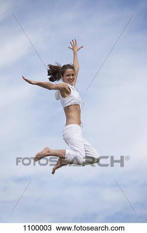 Exhilarated girl doing mid-air jump View Large Photo Image Stock Image - Exhilarated girl doing mid-air jump. Fotosearch