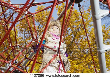 Girl daydreaming on jungle gym View Large Photo Image Stock Photograph - Girl daydreaming on jungle gym. Fotosearch