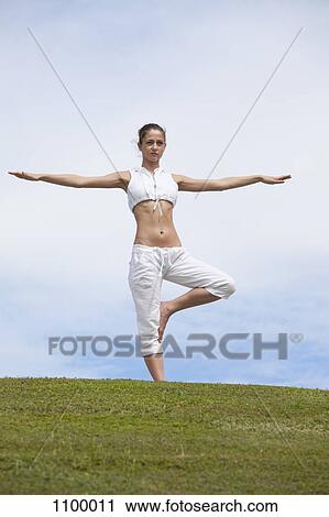 Girl does yoga pose on hillside View Large Photo Image Stock Image - Girl does yoga pose on hillside. Fotosearch