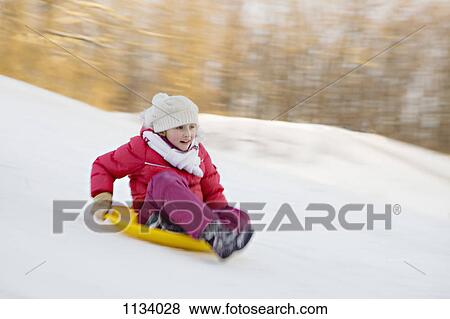 Girl going downhill on sledge View Large Photo Image Stock Photo - Girl going downhill on sledge . Fotosearch