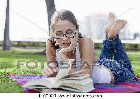 Girl lying down reading in park View Large Photo Image Stock Image - Girl lying down reading in park. Fotosearch