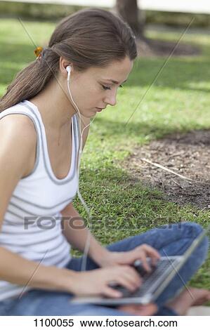 Girl on grass with legs crossed using laptop View Large Photo Image Stock Photography - Girl on grass with legs crossed using laptop. Fotosearch