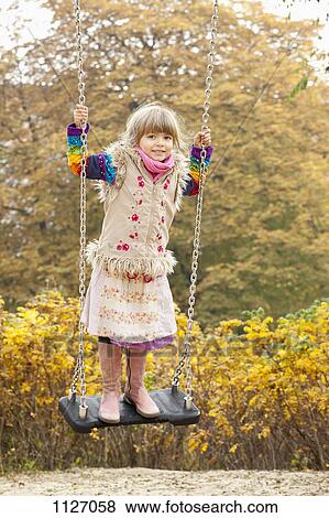Girl on swing in park View Large Photo Image Stock Photo - Girl on swing in park. Fotosearch