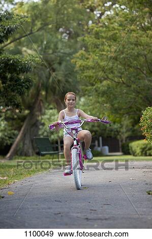 Girl riding bike through park View Large Photo Image Stock Photo - Girl riding bike through park. Fotosearch
