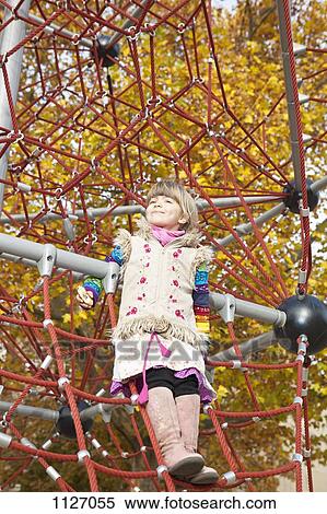 Girl standing on jungle gym View Large Photo Image Stock Photography - Girl standing on jungle gym. Fotosearch