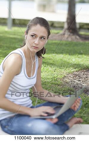 Girl with legs crossed in park using laptop View Large Photo Image Stock Image - Girl with legs crossed in park using laptop. Fotosearch