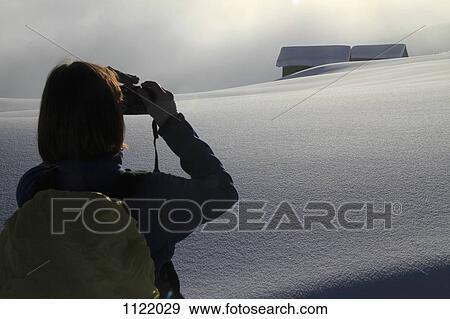 Hiker takes photograph of snowy log cabins in the distance View Large Photo Image Stock Photo - Hiker takes photograph of snowy log cabins in the distance. Fotosearch