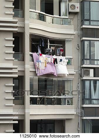 Stock Image - Laundry hanging from a balcony, Xiamen, China. Fotosearch