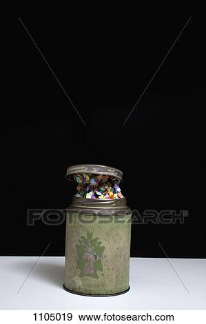 Lid opening of an old-fashioned metal tin containing confetti View Large Photo Image Stock Photo - Lid opening of an old-fashioned metal tin containing confetti. Fotosearch