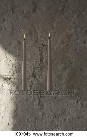Lit candles on a coat hanger View Large Photo Image Stock Photography - Lit candles on a coat hanger. Fotosearch