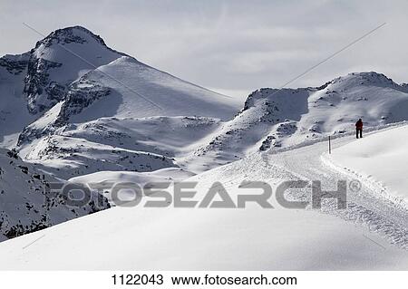 Lone hiker moving up snow hill View Large Photo Image Stock Image - Lone hiker moving up snow hill. Fotosearch