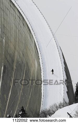 Stock Image - Lone man on the Zervreila Dam in Switzerland. Fotosearch