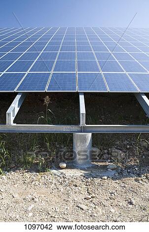 Stock Image - Low angle view of solar panels in a field. Fotosearch