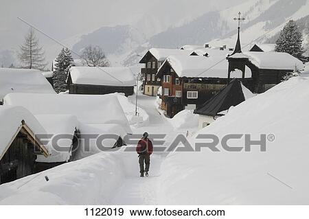 Man strolling through snow covered village View Large Photo Image Stock Photo - Man strolling through snow covered village. Fotosearch