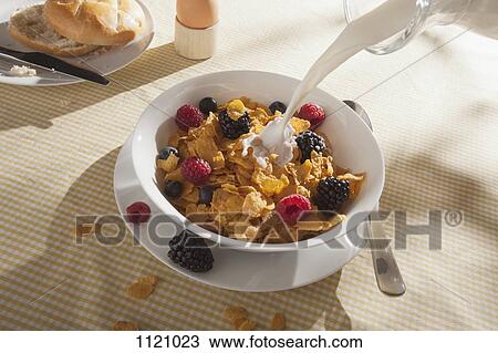 Milk being poured on a bowl of cornflakes with fruit View Large Photo Image Stock Image - Milk being poured on a bowl of cornflakes with fruit. Fotosearch