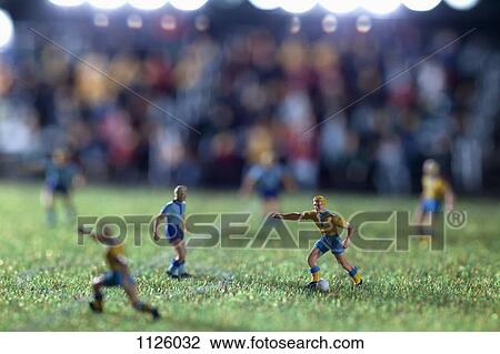 Stock Image - Miniature figurines of two soccer teams playing a soccer match. Fotosearch