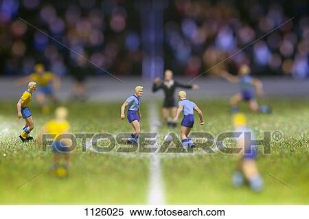 Stock Photography - Miniature soccer player figurines at the kick-off of a soccer match. Fotosearch