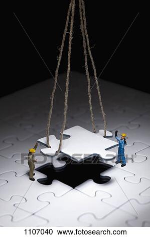 Miniature workmen guiding a hanging puzzle piece into place View Large Photo Image Stock Image - Miniature workmen guiding a hanging puzzle piece into place. Fotosearch