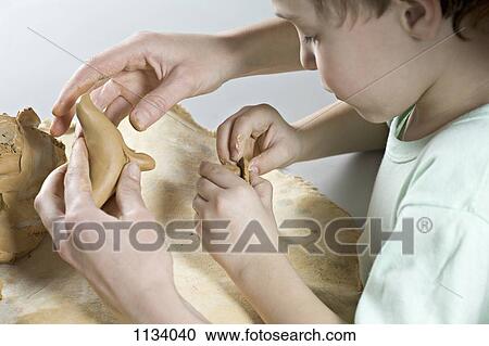 Mother gives son a helping hand with play clay View Large Photo Image Stock Image - Mother gives son a helping hand with play clay. Fotosearch