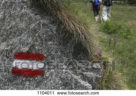 Stock Image - Painted symbol on a rock marking a hiking trail, Piedmont, Italy. Fotosearch