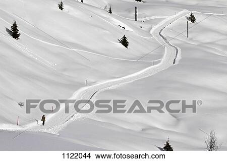Person walking up hill through snow laden footpath View Large Photo Image Picture - Person walking up hill through snow laden footpath. Fotosearch