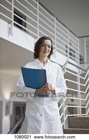 Stock Image - Portrait of a doctor holding a file. Fotosearch