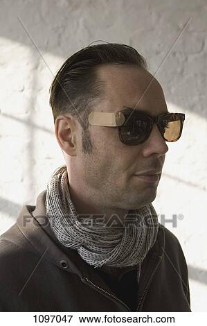 Portrait of a man wearing sunglasses attached with an adhesive bandage View Large Photo Image Stock Photo - Portrait of a man wearing sunglasses attached with an adhesive bandage. Fotosearch