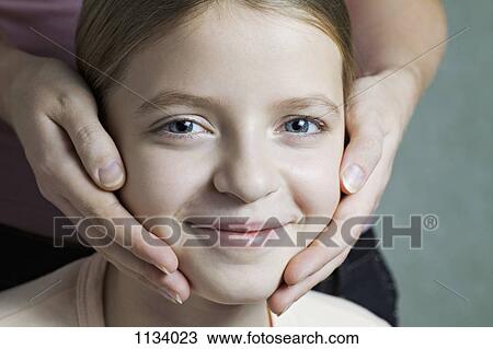 Portrait of daughter with Mother's hands on her cheeks View Large Photo Image Stock Image - Portrait of daughter with Mother's hands on her cheeks. Fotosearch
