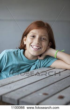 Portrait of young girl leaning against table View Large Photo Image Stock Photograph - Portrait of young girl leaning against table. Fotosearch