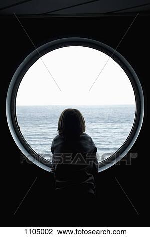 Rear view of a boy looking through a porthole View Large Photo Image Stock Image - Rear view of a boy looking through a porthole. Fotosearch