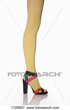 Stock Photo - Side view of a woman wearing yellow tights and high heels, low section. Fotosearch