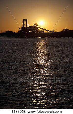 Silhouette of a bucket wheel reclaimer at an iron ore mine View Large Photo Image Stock Photo - Silhouette of a bucket wheel reclaimer at an iron ore mine. Fotosearch