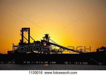 Silhouette of a bucket wheel reclaimer at an iron ore mine View Large Photo Image Stock Photograph - Silhouette of a bucket wheel reclaimer at an iron ore mine. Fotosearch