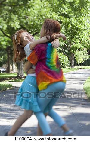 Sister hugs in the park View Large Photo Image Picture - Sister hugs in the park. Fotosearch