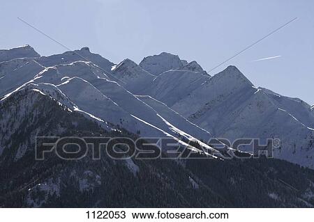 Snow-capped mountain range with vapor trail of plane in background View Large Photo Image Stock Image - Snow-capped mountain range with vapor trail of plane in background. Fotosearch