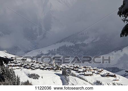 Snowy village with mountain range and valley in the background View Large Photo Image Stock Photograph - Snowy village with mountain range and valley in the background. Fotosearch