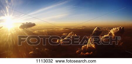Stock Image - Sun rising on clouds, aerial view. Fotosearch